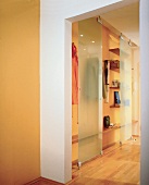 Flur mit Glasschiebetüren vor der Garderobe, gelbe Wände