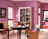 Essplatz mit klassischem Holztisch, Korbstühlen und violetten Wänden