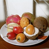 Teller mit exotischen Früchten Tamarillo, Kiwano, Kokosnuß