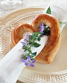 Heart shape made out of yeast dough with flower and paper napkin