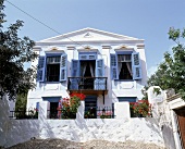 Restaurierte alte Villa von außen weiß gestrichen, blaue Fensterläden