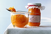 Close-up of apricot and cape gooseberries sauce in glass jars on table