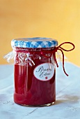 Blood orange and strawberry jam in glass jar with masking tape on lid