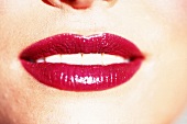 Frauenmund mit kräftig geschminkten Lippen in glänzendem Rot
