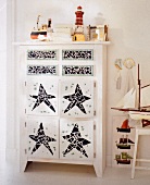 White chest of drawers decorated with tile shards