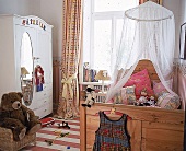 Kinderzimmer mit antikem Kleiderschrank u. rustikalem Holzbett