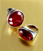 Close-up of silver plated round and oval ring with red stones