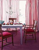Puristischer Tisch mit braunen Stühlen und rotem Teppich.