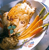 Close-up of spring chicken with carrots and risotto on plate