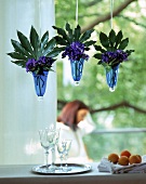 Blaue Windlicher zum Aufhängen, zu kleinen Vasen umfunktioniert