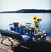 gedeckter Tisch, der auf einem Bootssteg am See steht - sommerlich