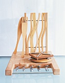 Wooden kitchenware with different knives on glass table