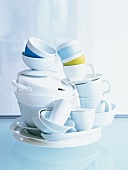 Stack of white dishes, cups and bowls on table