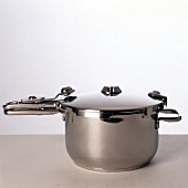 Stainless steel pressure cooker on gray surface