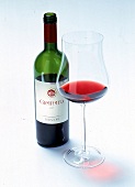 Offene Flasche Rotwein (Granato), daneben Glas mit ein wenig Rotwein.