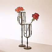 Zwei Glasvasen mit langstieligem Metallfuß,je eine einzelne rote Rose