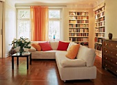 Wohnzimmer mit großen hellen Ecksofa, Parkett, Bücherregalen