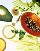 Close-up of algae, wheat, thin slices of lemon, avocado and papaya on white background