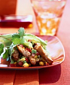 Close-up of roasted chicken breast with corn and peppers on plate