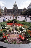 prunkvolles gebäude in Prag mit Vorplatz ,blühendem Beet, Kreuz