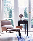 Designer-Holzstuhl mit hellem Bezug, aufgeschlagenes Buch auf dem Sitz