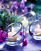 Lit candle in modern glass on table in garden