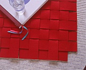 Teppich aus verflochtenen roten Filzstreifen