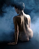 Rear view of nude woman sweating while having steam bath in steam room