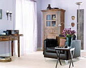 Wohnraum mit massiven Holzmöbeln, modernem Sessel, hellem Parkett