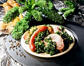 Kale, bacon and pinkel on plate with raw kale in background