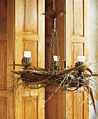 Close-up of chandelier with candles, pheasant feathers and jewellery wreath