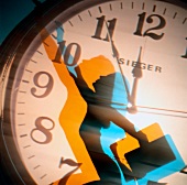 Close-up of woman's multi-coloured shadow on clock face