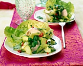 Salad with chicken strips, cucumber, red pepper, salad leaves and lime sauce on plate