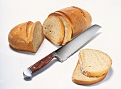 aufgeschnittener Brotlaib mit einzelnen Scheiben und Brotmesser