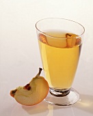 Ein Glas mit Apfelsaft,Freisteller neben dem Glas liegt ein Stück Apfel