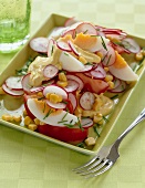 Salad with egg, radishes, corn, tomatoes and yogurt curry sauce on plate