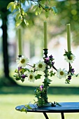Close-up of candlestick with entwined flowers in garden