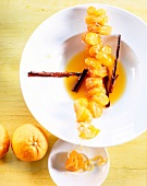 Seville oranges with syrup and cinnamon sticks on plate