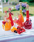 Plate with various berries and carafes with peach and berry liqueur