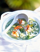 Close-up of peas and pear soup with rice noodles and scallops in bowl