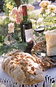 Trentiner Nussbrot mit Käse + Wein im Garten angerichtet