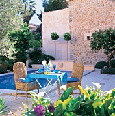 Terrasse im Südländischem Stil, Flechtstühle mit blauen Kissen