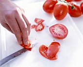 Close-up of man's hands gutting and skinning tomatoes