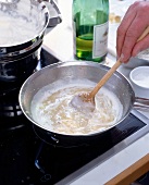 Whipped cream is added into rice while preparing Risotto
