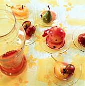 Close-up of pickled peaches, pears and plums on small glass plates