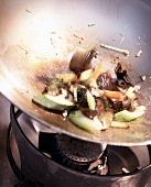 Close-up of bami goreng being prepared with mushrooms in a wok
