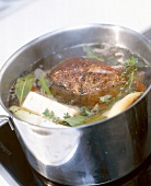 Close-up of roast beef being cooked in a pot