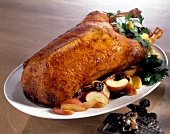 Roasted goose with apples and prunes on serving dish