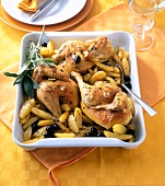Baked chicken with olives, herbs and potatoes in serving dish