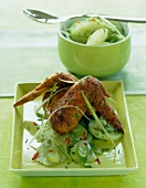 Chicken wings with cucumber salad in serving dish